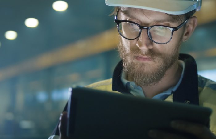 11Technician looking at tablet in industrial setting