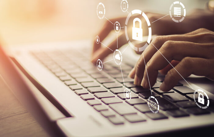 person typing on a laptop with lock and security icons