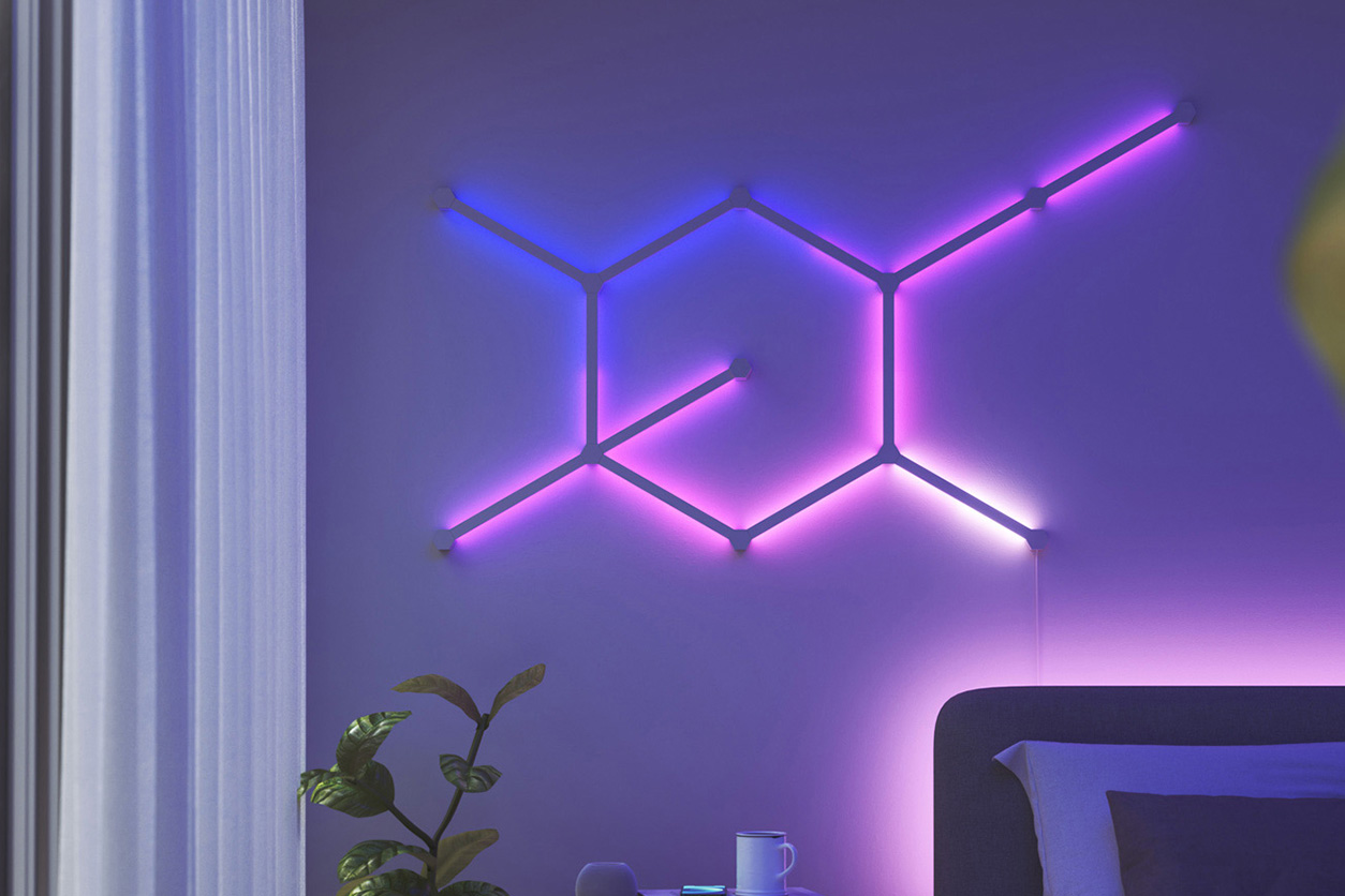 A bedroom with a bed and a purple neon light illuminating the space.
