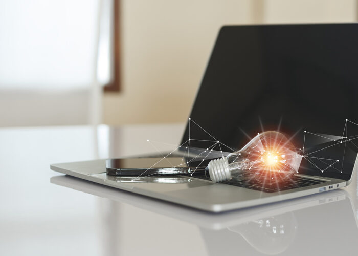 A laptop with a light bulb on top, symbolizing creativity and innovation.
