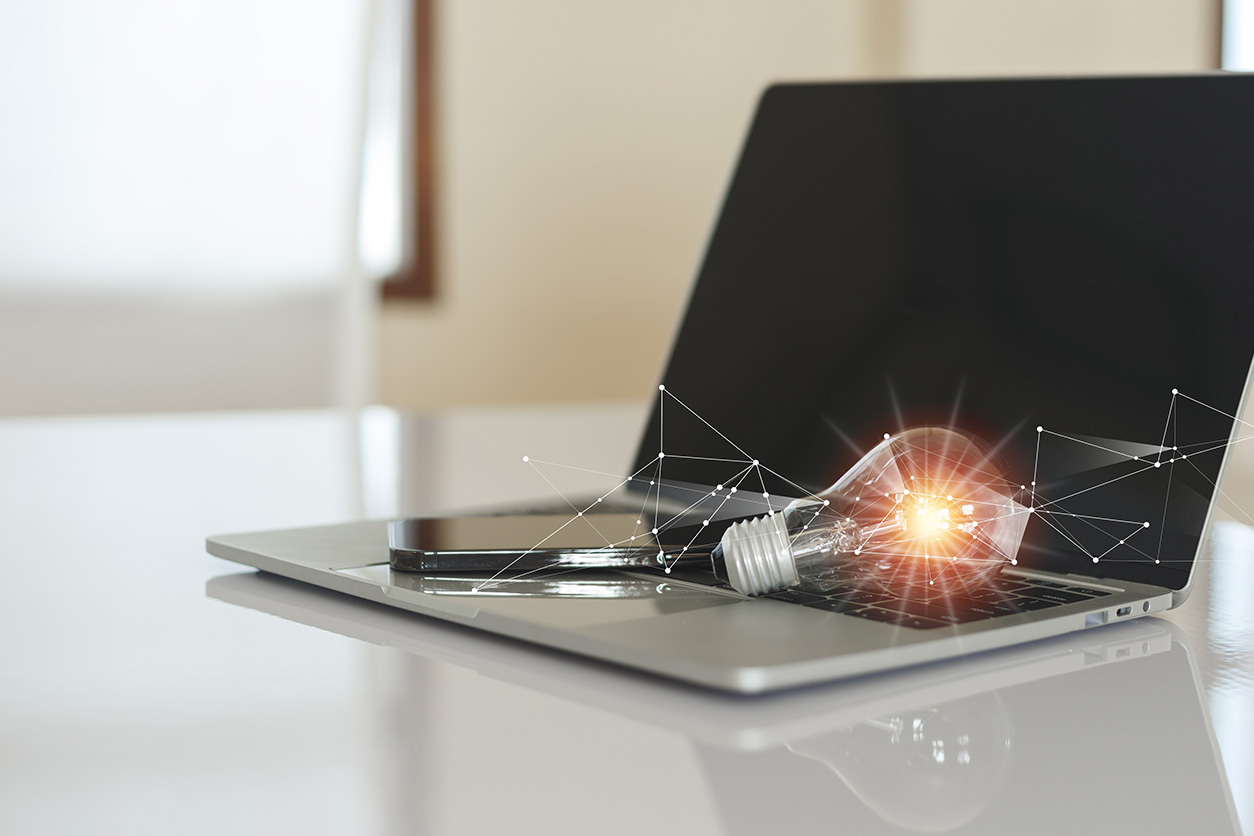 A laptop with a light bulb on top, symbolizing creativity and innovation.