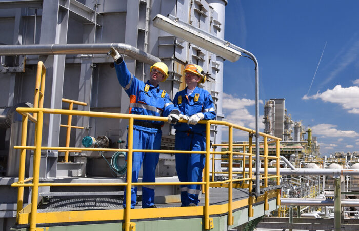 Two workers standing on pedway pointing into the distance