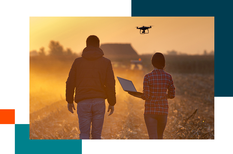 People standing in field with drone flying over head