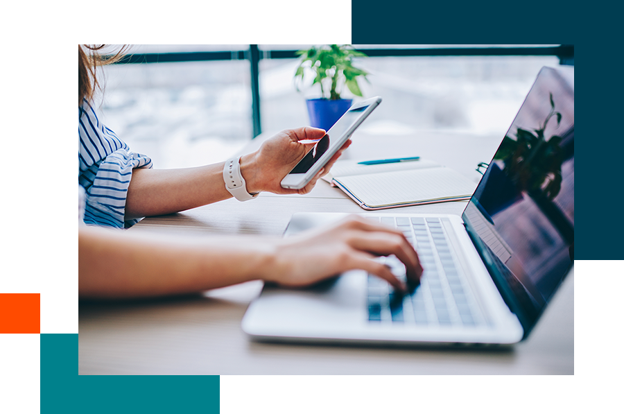 Woman using laptop and phone