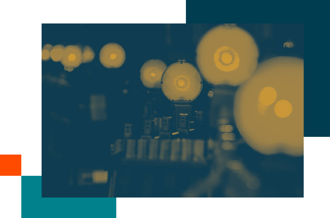 Row of illuminated light bulbs with a central bulb in sharp focus against a dark background, highlighting filament details and industrial setup.