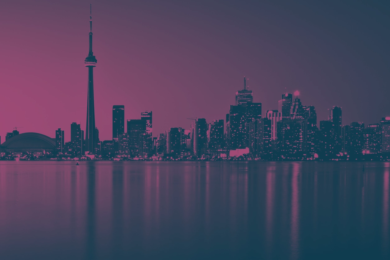 Toronto skyline at dusk, featuring the CN Tower and city buildings reflected on the water, with a pink and blue colour treatment.